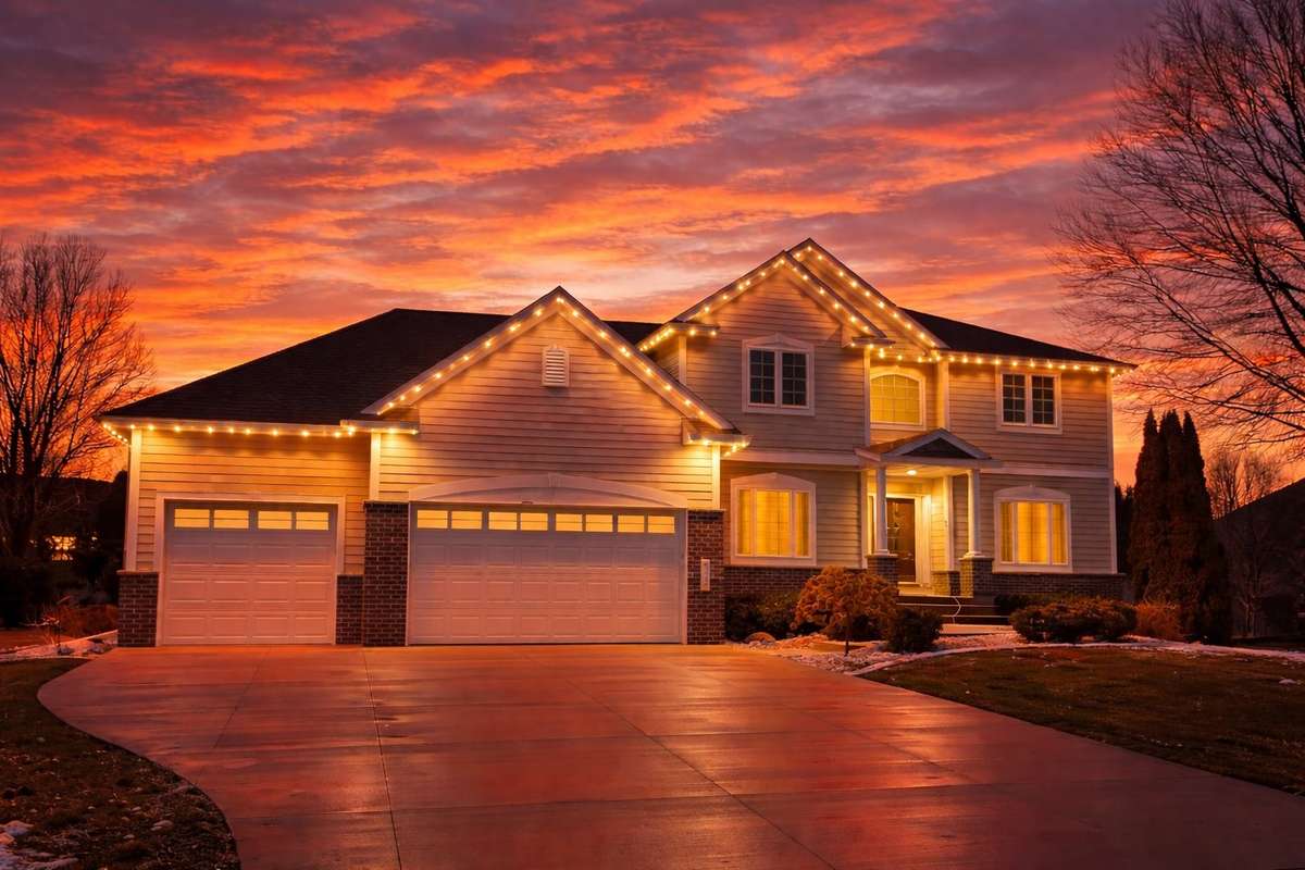 Warm white lights on suburban home at sunset