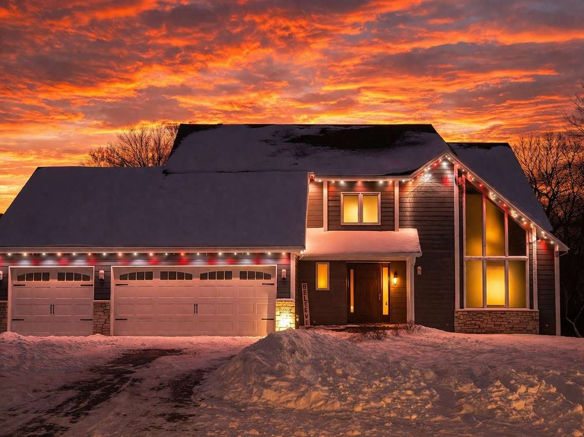 Christmas lights on craftsman home at dramatic sunset, Minnesota